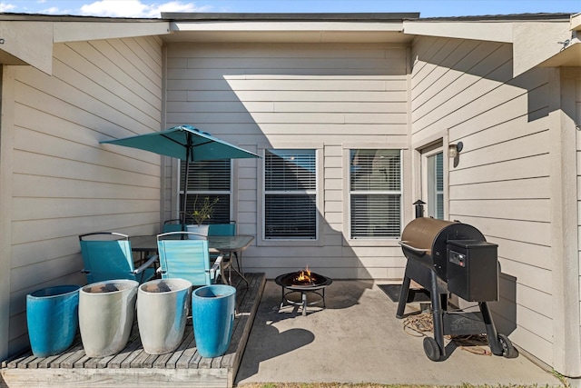 view of patio featuring a grill, outdoor dining area, and an outdoor fire pit