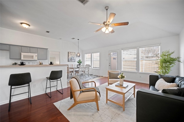 living area with wood finished floors, baseboards, visible vents, lofted ceiling, and ceiling fan