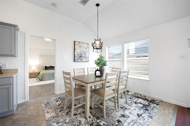 dining space featuring visible vents, baseboards, an inviting chandelier, and vaulted ceiling