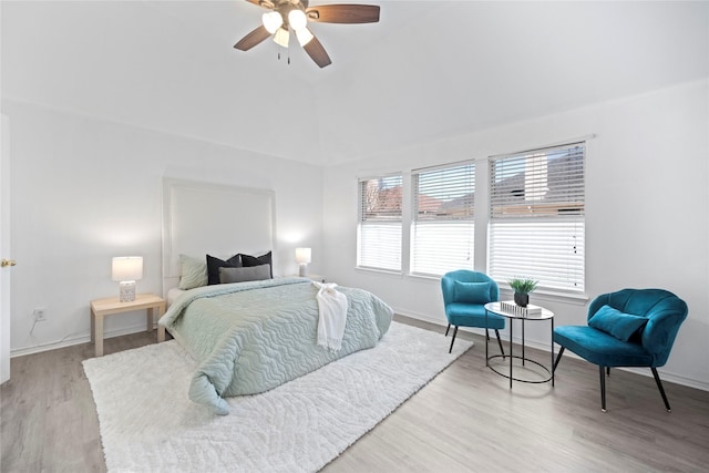 bedroom with vaulted ceiling, a ceiling fan, baseboards, and wood finished floors