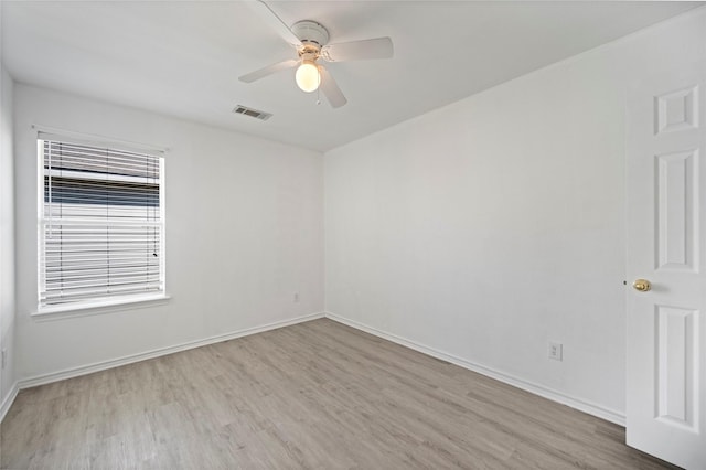 empty room featuring visible vents, baseboards, wood finished floors, and a ceiling fan