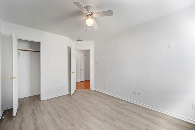 unfurnished bedroom with visible vents, wood finished floors, a closet, baseboards, and ceiling fan