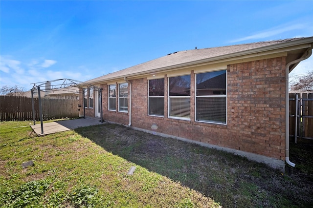 back of house featuring brick siding, fence, a gazebo, a yard, and a patio area