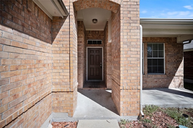 doorway to property featuring brick siding