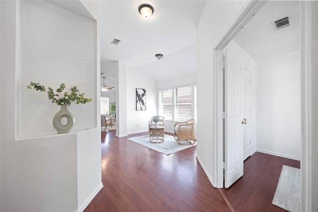 hallway with visible vents, a healthy amount of sunlight, and wood finished floors