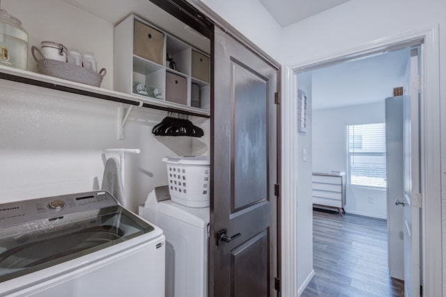 washroom featuring laundry area, wood finished floors, and washing machine and clothes dryer