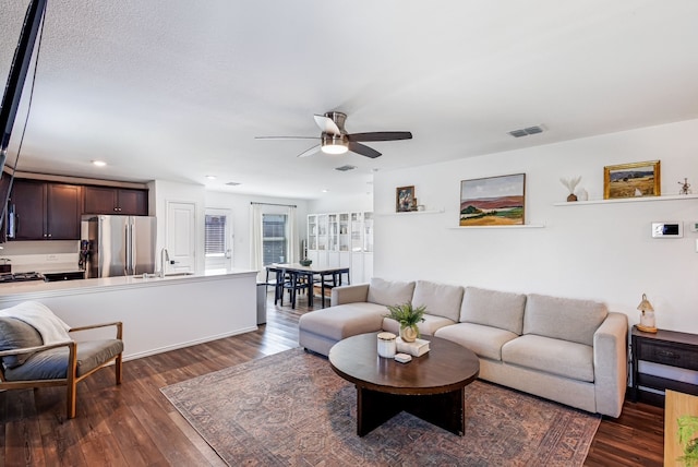 living room with recessed lighting, visible vents, dark wood-type flooring, and a ceiling fan