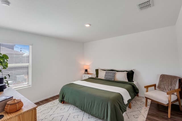 bedroom with recessed lighting, visible vents, baseboards, and wood finished floors