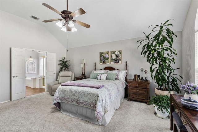 bedroom featuring visible vents, high vaulted ceiling, ensuite bath, ceiling fan, and light carpet