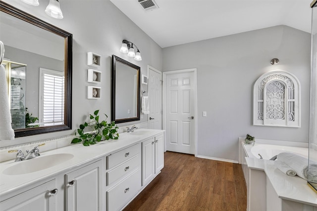 bathroom featuring double vanity, visible vents, wood finished floors, and a sink