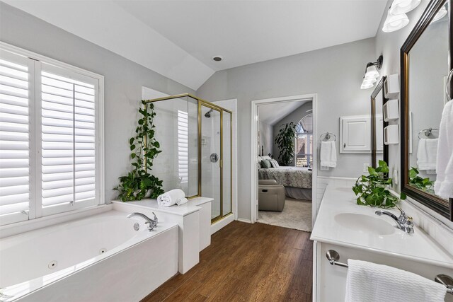 ensuite bathroom with ensuite bath, a stall shower, a sink, vaulted ceiling, and a jetted tub