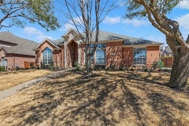 single story home with brick siding, a front yard, and fence