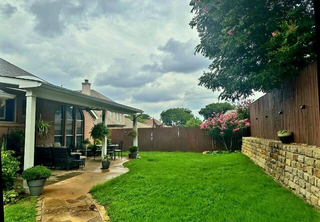 view of yard with an outdoor living space, a patio area, and fence