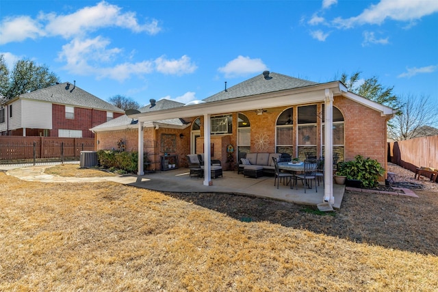 rear view of property with brick siding, fence private yard, central AC unit, outdoor lounge area, and a patio