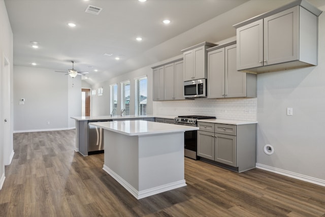 1817 Forest Wood, Mesquite, TX 75181 - kitchen featuring appliances with stainless steel finishes, gray cabinetry, a ceiling fan, backsplash, and a peninsula