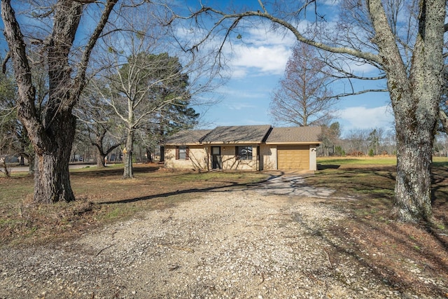 view of front facade with an attached garage and dirt driveway