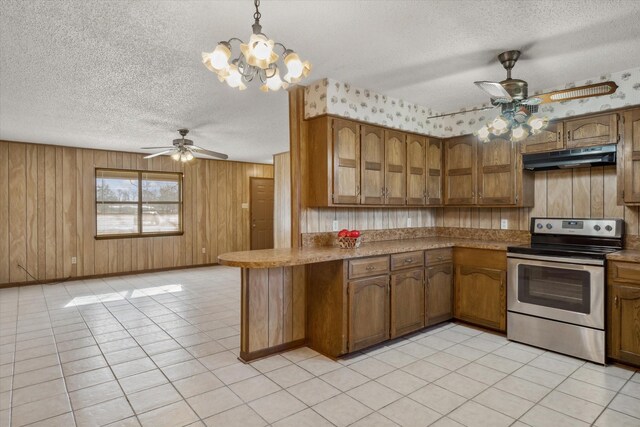 kitchen with brown cabinets, stainless steel range with electric stovetop, under cabinet range hood, a textured ceiling, and a peninsula