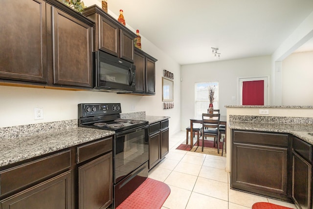 kitchen with light tile patterned floors, light stone countertops, dark brown cabinetry, and black appliances