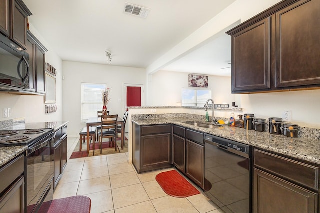 kitchen featuring visible vents, dark brown cabinets, light tile patterned floors, black appliances, and a sink