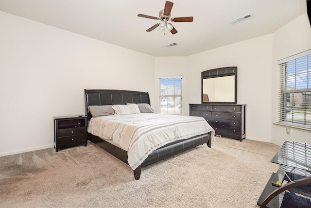 carpeted bedroom with visible vents, baseboards, and ceiling fan