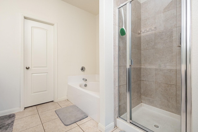 full bath featuring a shower stall, a garden tub, baseboards, and tile patterned floors