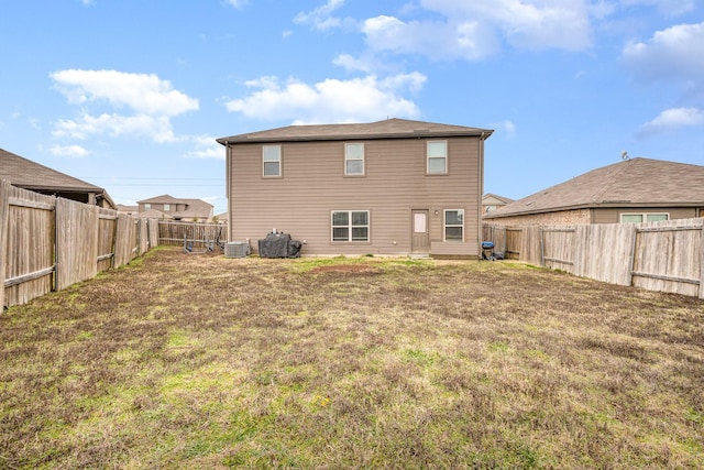 back of house featuring central AC unit, a yard, and a fenced backyard