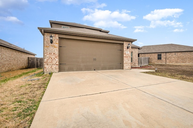 prairie-style house with brick siding, concrete driveway, and fence