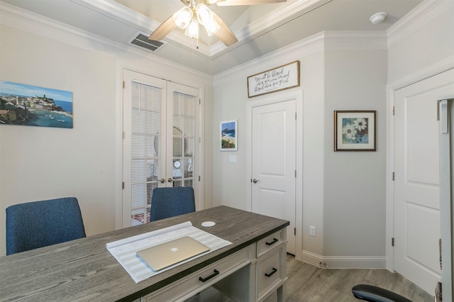 office space featuring light wood finished floors, visible vents, crown molding, baseboards, and ceiling fan