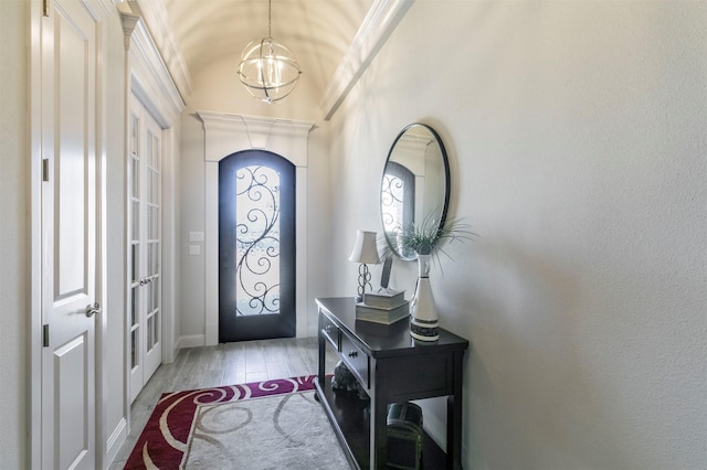 entryway featuring a chandelier, light wood-type flooring, and vaulted ceiling