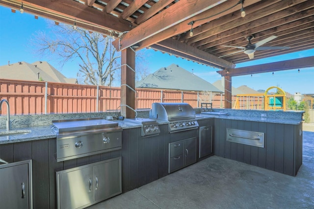 view of patio / terrace with ceiling fan, a grill, exterior kitchen, and a fenced backyard