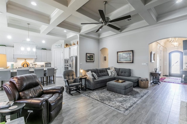 living room with a high ceiling, beamed ceiling, and arched walkways