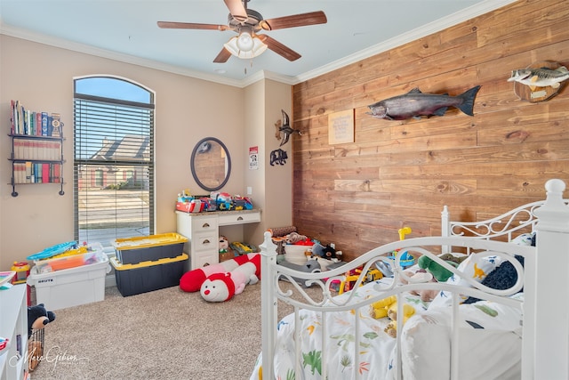 bedroom with wood walls, crown molding, carpet, and ceiling fan