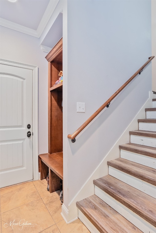 mudroom with light tile patterned floors and ornamental molding