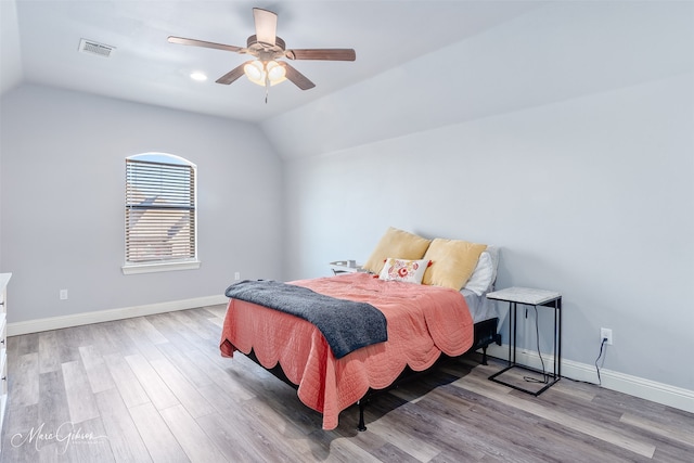 bedroom with vaulted ceiling, visible vents, baseboards, and light wood finished floors