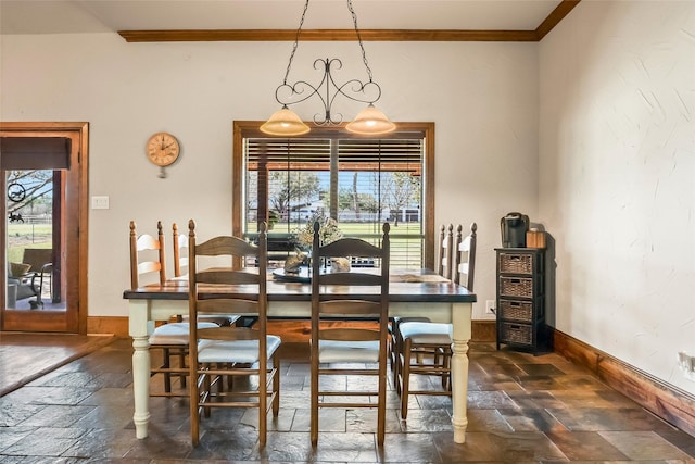 dining room with crown molding, stone tile floors, and baseboards