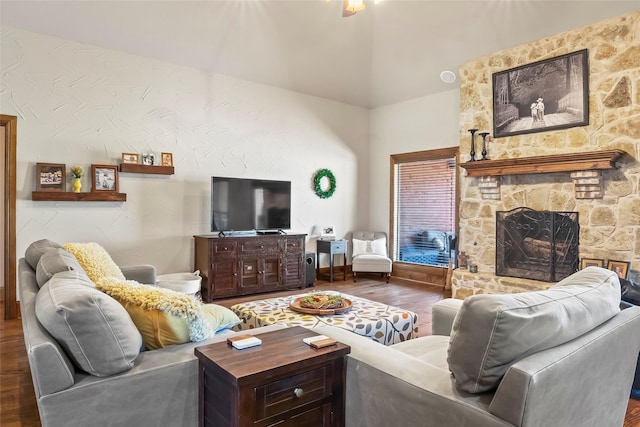 living room featuring a fireplace, lofted ceiling, and wood finished floors