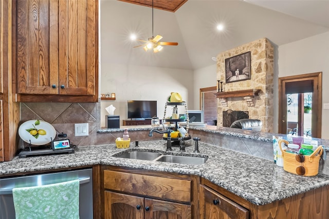 kitchen with a sink, stainless steel dishwasher, open floor plan, brown cabinetry, and decorative backsplash