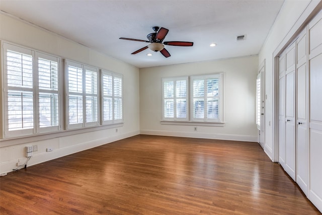 unfurnished bedroom with visible vents, multiple windows, and wood finished floors