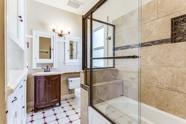 bathroom with visible vents, toilet, shower / bath combination with glass door, tile patterned floors, and vanity