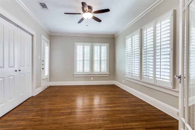 foyer entrance with visible vents, ornamental molding, dark wood-style floors, baseboards, and ceiling fan