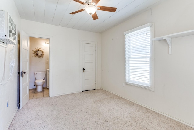 unfurnished bedroom featuring carpet flooring, ensuite bathroom, and ceiling fan