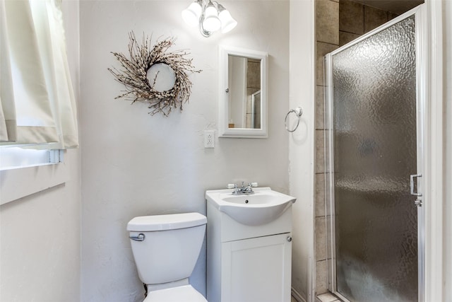 full bath featuring toilet, a stall shower, and vanity