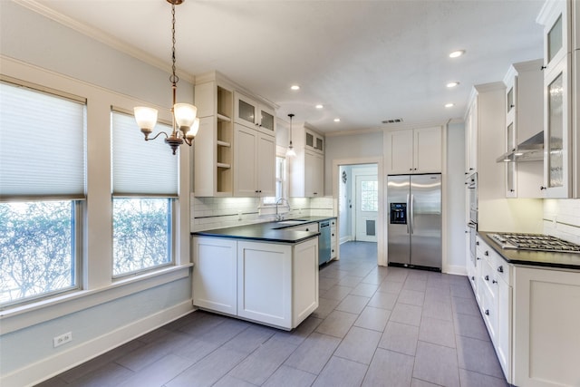 kitchen featuring a peninsula, open shelves, ornamental molding, stainless steel appliances, and dark countertops