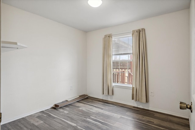 unfurnished room with dark wood-style floors and baseboards