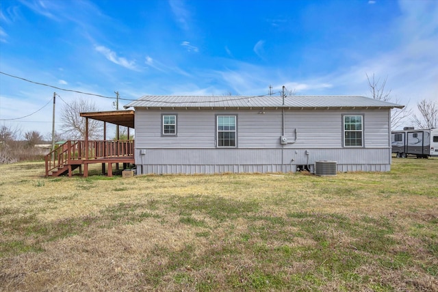 view of property exterior with metal roof, a lawn, and cooling unit