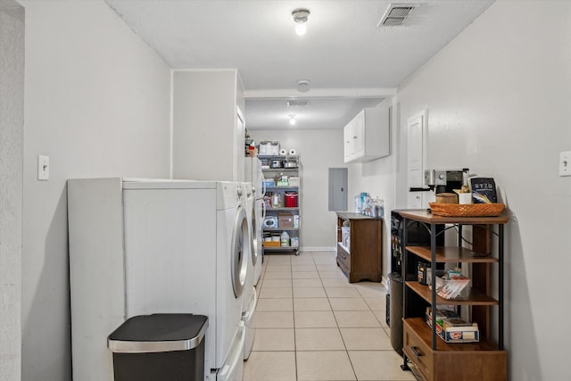 washroom featuring visible vents, electric panel, washer and dryer, light tile patterned floors, and laundry area