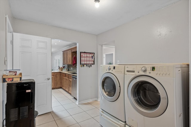 clothes washing area with light tile patterned floors, independent washer and dryer, and laundry area