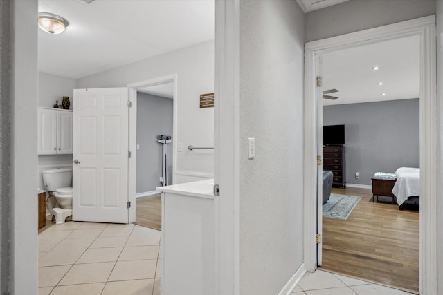 ensuite bathroom featuring tile patterned flooring, baseboards, toilet, ensuite bathroom, and vanity