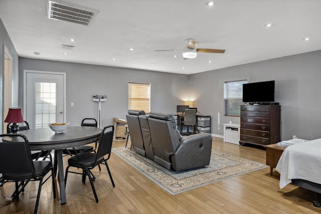 living area with a ceiling fan, visible vents, light wood finished floors, baseboards, and recessed lighting