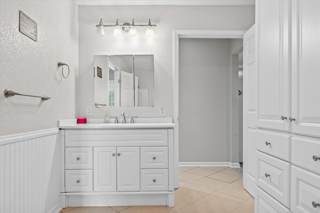 bathroom featuring tile patterned floors, a wainscoted wall, and vanity